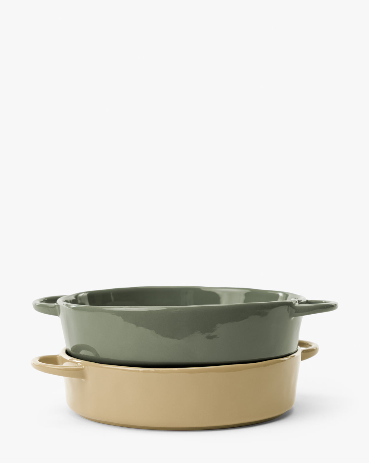 The 2 Quart Stoneware Baker (Set of 2) features two oval bakers with handles, stacked on a white background; one is green, the other beige, both with a glossy finish by McGee & Co.