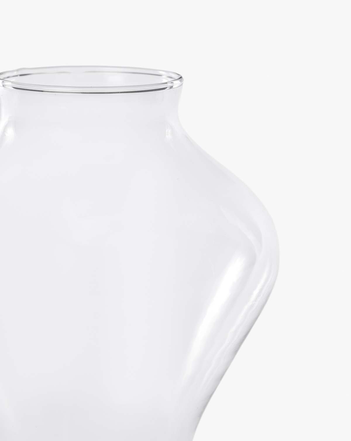 A close-up of the Allaire Glass Vase, featuring a handblown curved design, set against a plain white background, by McGee & Co.