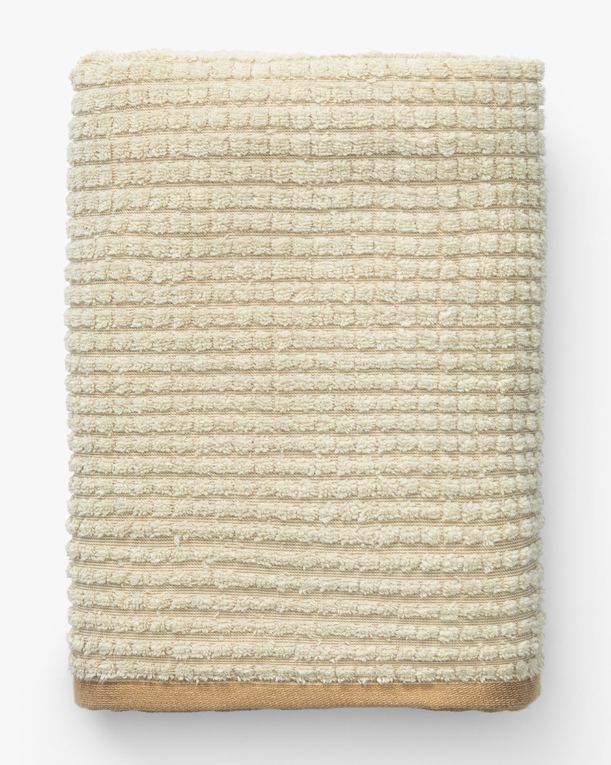 A neatly folded beige waffle weave towel from the Atrani Organic Bath Collection features a grid-like pattern and solid edge, shown from above on a white background, by McGee & Co.
