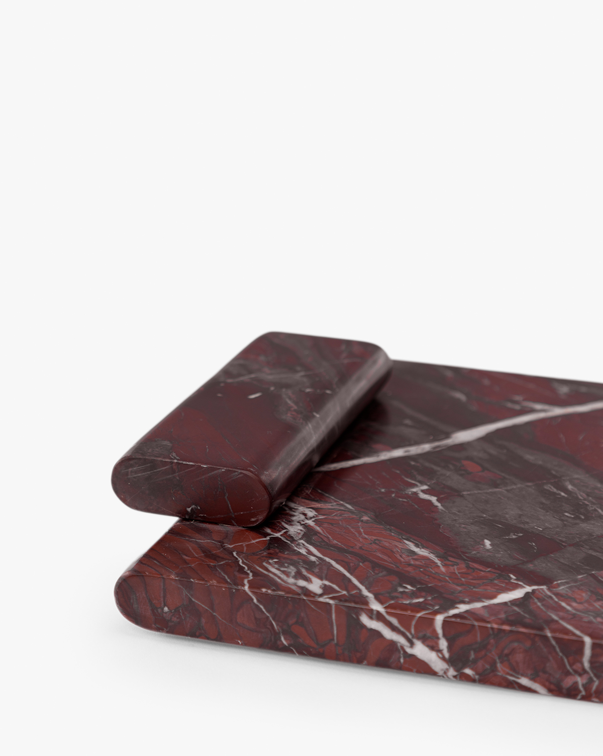 An Auburn Marble Tray with white veining patterns is displayed on a white background, accompanied by a matching dark red marble rolling pin, by McGee & Co.