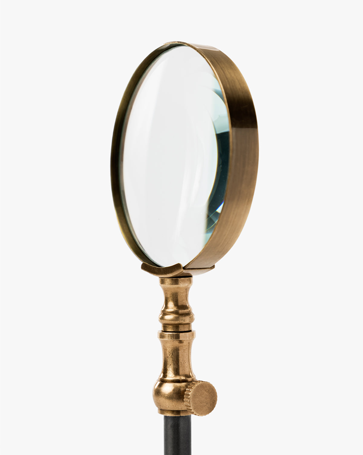 The Barnabas Standing Object features a vintage round clear lens and a burnished brass handle, standing upright against a white background—an ideal accent to bring classic charm to your home decor, by McGee & Co.