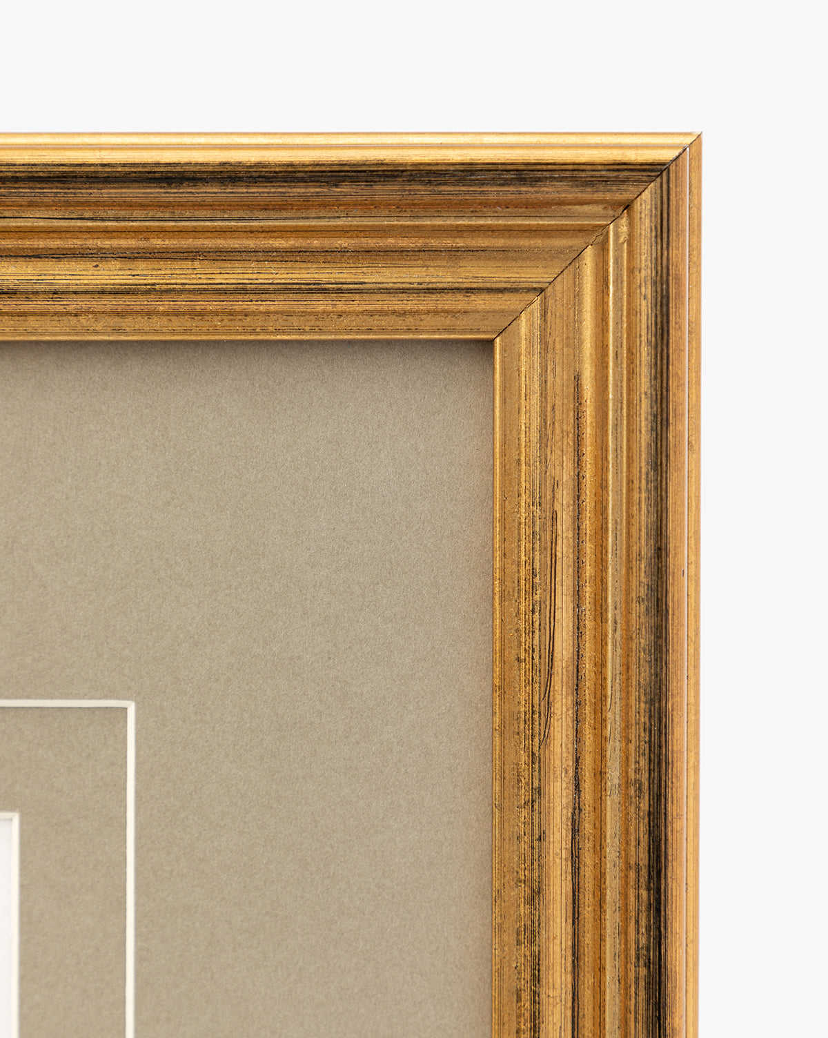 Close-up of the top right corner of an antique gold frame with a neutral beige matte, highlighting its textured, slightly worn finish—an ideal choice for displaying vintage wall art or petite florals like Blossoming Branch, by McGee & Co.
