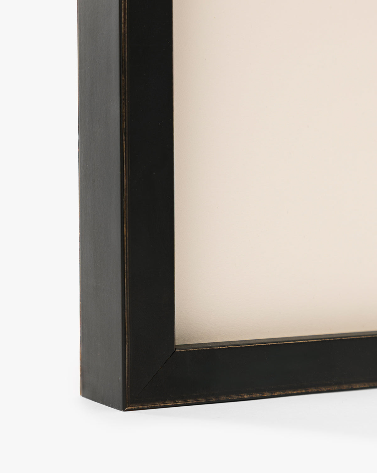 Close-up of the corner of a black, rectangular frame with a beige background, highlighting its modern edges and thickness—an ideal way to display Bright Horizons by Donna Thomas as stunning giclée print wall art, by McGee & Co.