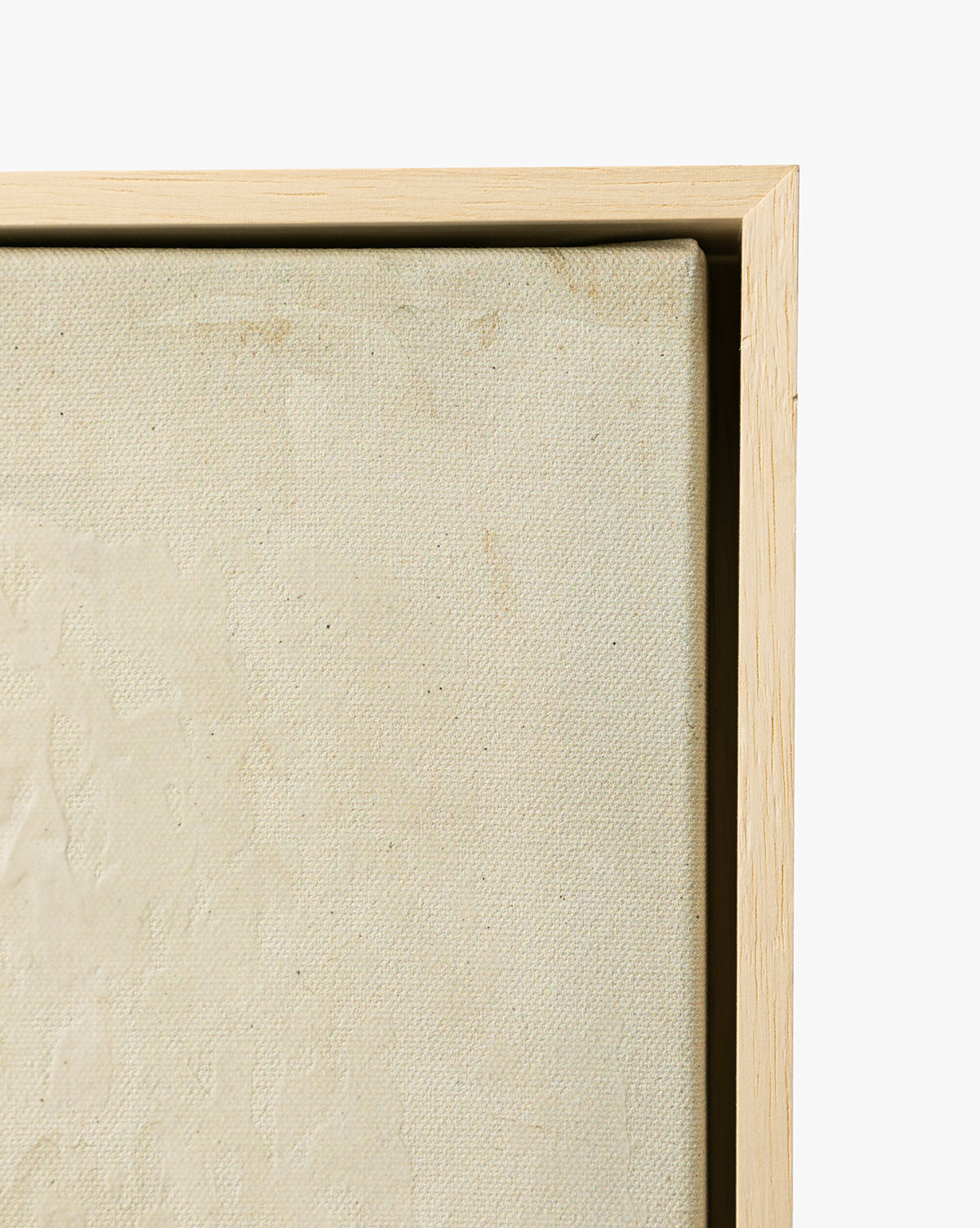 Close-up of the corner of Brushes in Neutral, a textured canvas in a light wood frame—ideal as neutral wall art or framed giclée—set against a white background, by McGee & Co.