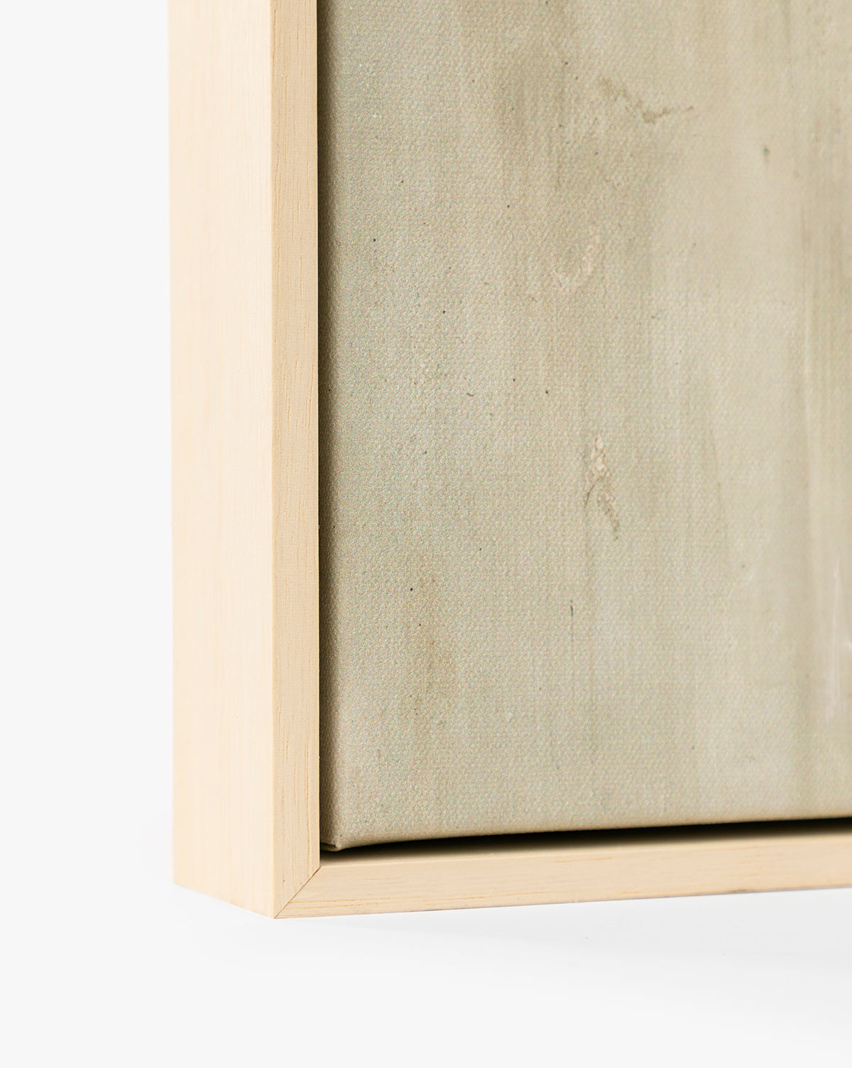 Close-up of the corner of the Brushes in Neutral light wood picture frame with canvas inside, showcasing the texture of neutral canvas art and the smooth frame set against a plain white background, by McGee & Co.