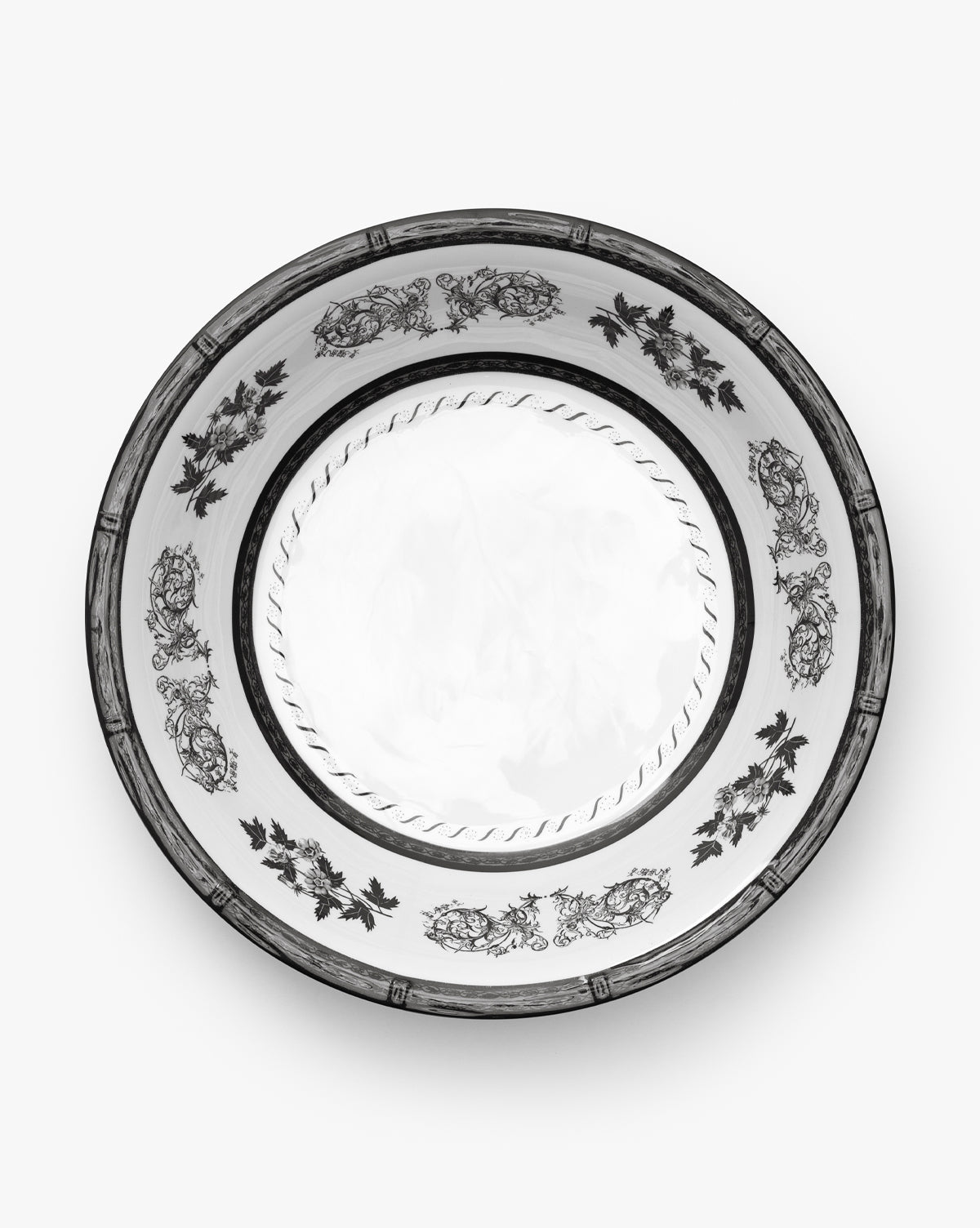 The Calanthe Melamine Serving Bowl features an ornate black floral and leaf pattern around the rim with a simple rope-like design at the center, reminiscent of vintage styles, by McGee & Co. Presented from above against a plain white background.