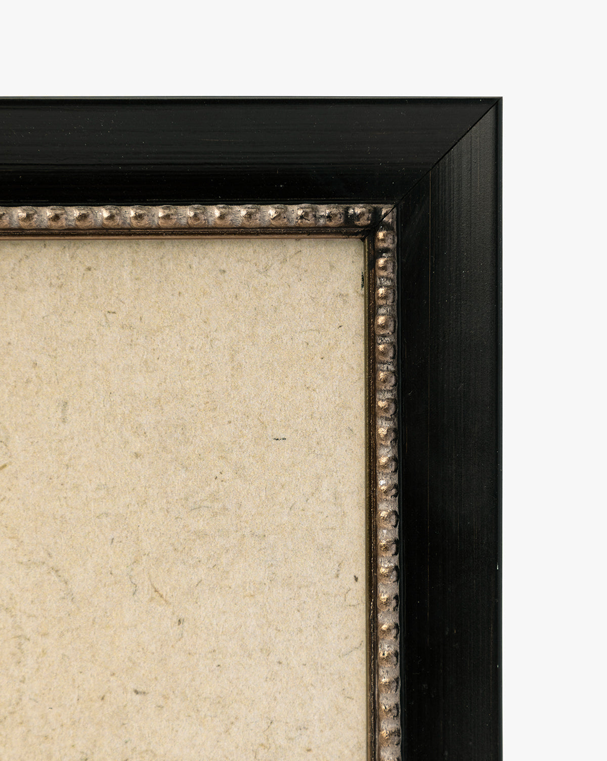 Close-up of the top right corner of a black frame with decorative beading and a textured beige background—ideal for displaying Clouded Island as a giclée on paper or highlighting its detailed landscape features, by McGee & Co.