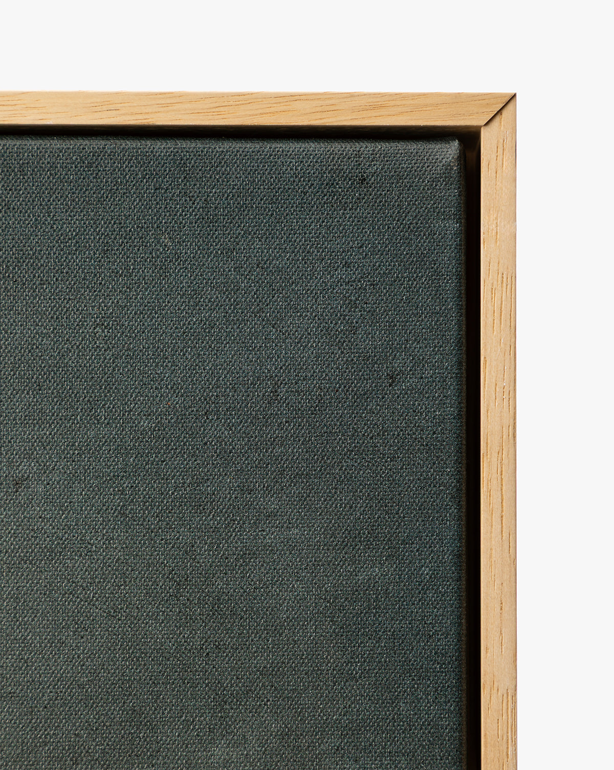 Close-up of the top right corner of the Clouds Over Mountains stretched dark canvas in a light wooden frame, showcasing this moody framed art against a white background, by McGee & Co.