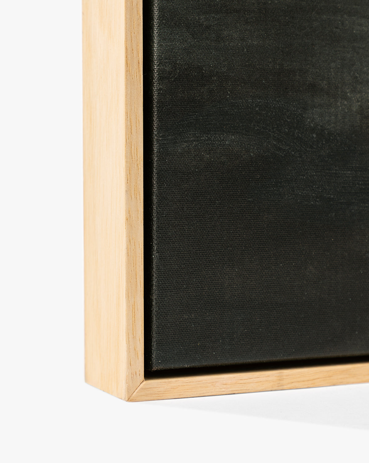 Close-up of the corner of Clouds Over Mountains, a black canvas in a light wood frame against a white backdrop—an elegant detail perfect for fans of moody, atmospheric wall art, by McGee & Co.