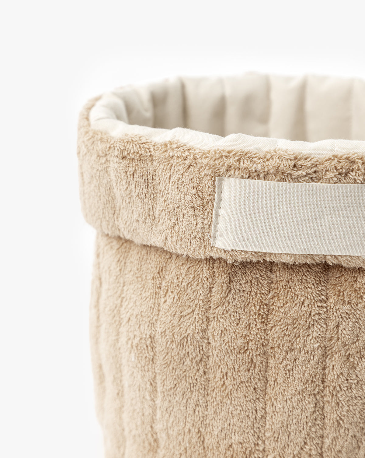 Close-up of Cotton Terry Cloth Baskets (Set of 3) in beige with a textured, plush surface, white side label, quilted padded lining, and foldable design for easy organization, by McGee & Co.