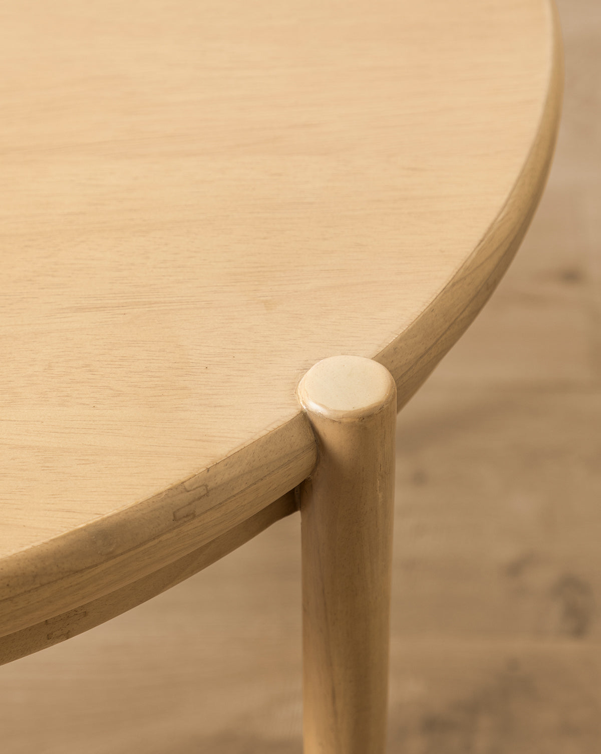 Close-up of the Darcy Kids Table, a round light wood table crafted from white oak, highlighting its smooth tabletop edge and rounded leg with a natural wood grain finish, by McGee & Co.
