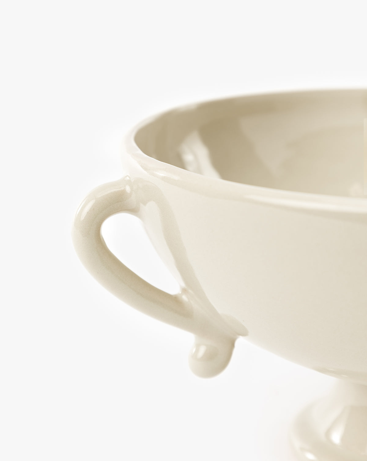 Close-up of the Delphine Footed Bowl, a cream-colored ceramic piece with a handle, set against a plain white background, by McGee & Co.