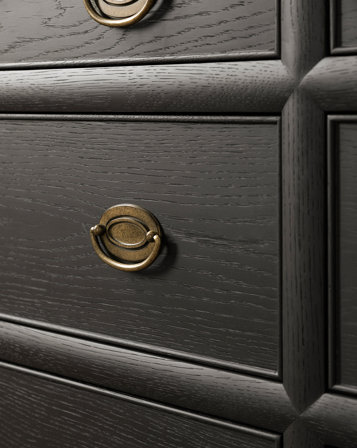 Close-up of the Edward Dresser in Black Ash finish, showcasing textured grain, round brass drawer pulls, and raised rectangular panel details—a stylish storage solution for bedrooms, by McGee & Co.