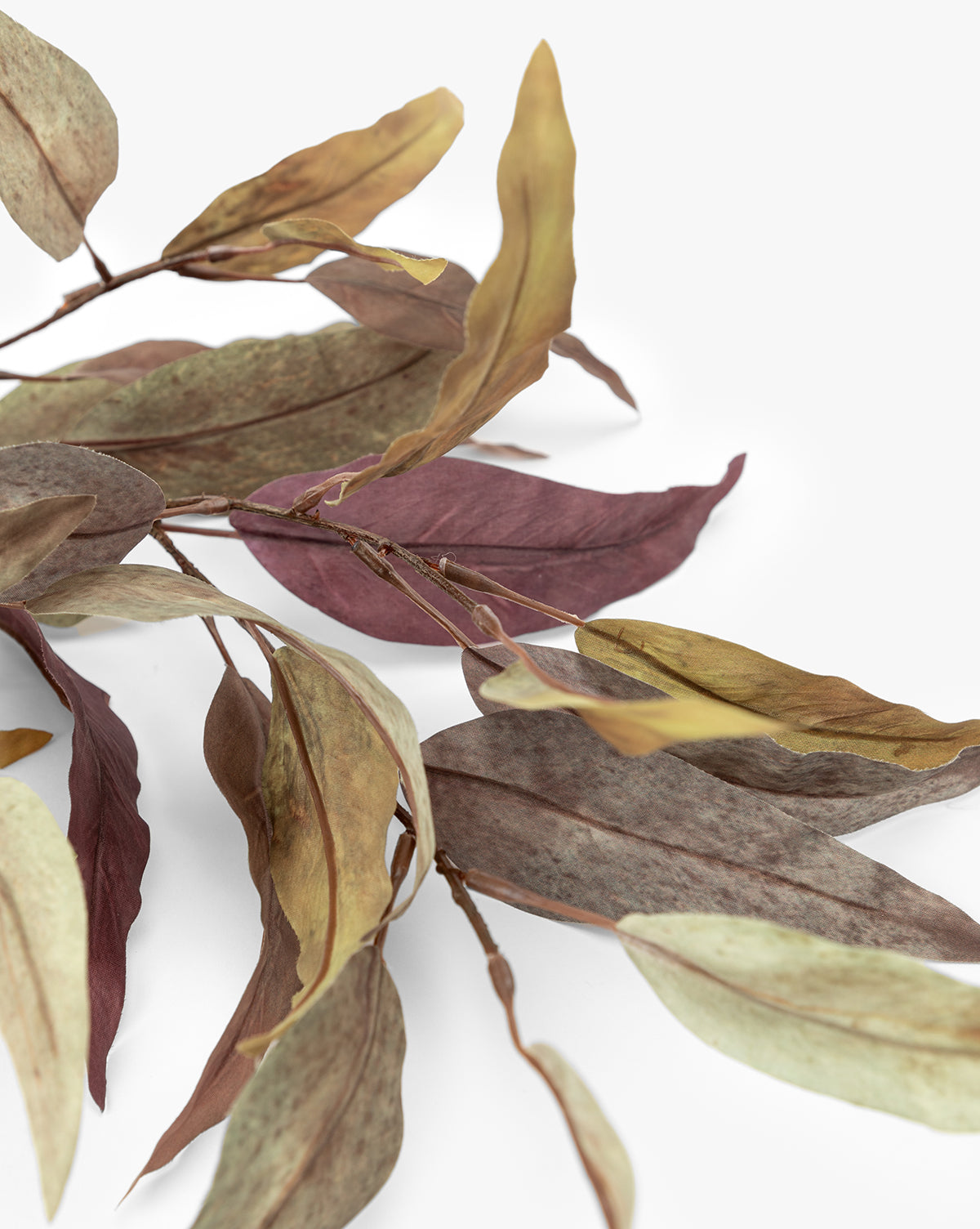 A close-up of the Faux Purple Eucalyptus Stem displays dried eucalyptus leaves in brown, green, and purple tones against a white background—highlighting its lifelike texture, perfect for seasonal centerpieces or as an accent, by McGee & Co.