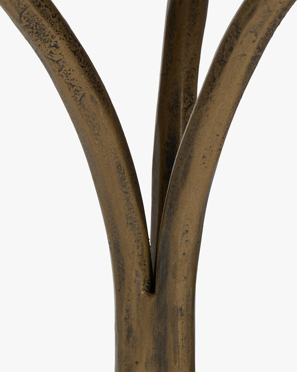 Close-up of three bronze-colored, slightly curved metal rods converging at the base, highlighting the hammered aged brass detail of the Fossil Marble End Table against a plain white background, by McGee & Co.