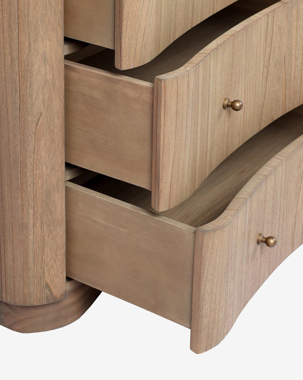 Close-up of the Gatlin Chest, made from solid mindi wood with a light natural finish, by McGee & Co. It features three spacious curved drawers and round brass knobs.