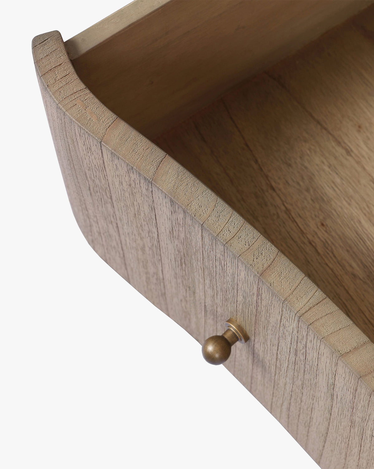 A close-up of an open drawer from the Gatlin Chest highlights its spacious, empty interior, solid mindi wood grain, and a small round brass knob by McGee & Co.