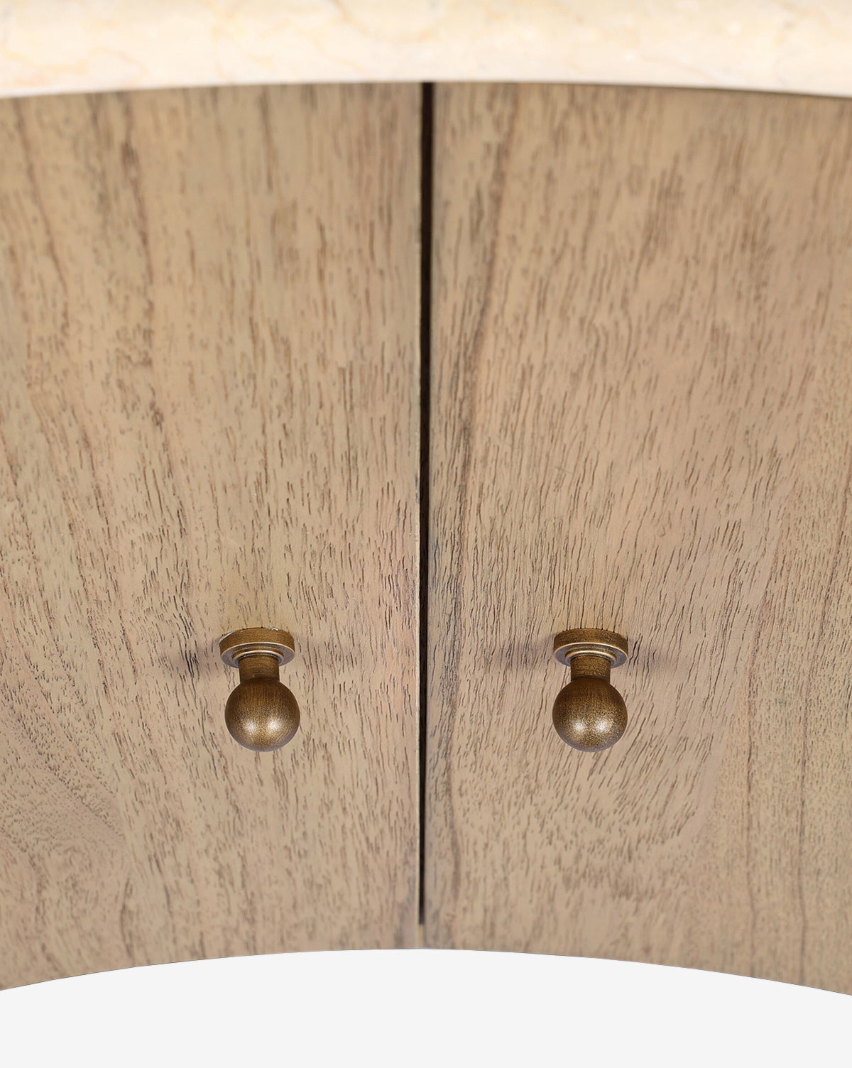 Close-up of the Gatlin Nightstand’s two solid mindi wood cabinet doors, detailed with round brass knobs, a vertical seam, and a natural finish that highlights the wood grain—ideal for elegant bedside storage, by McGee & Co.