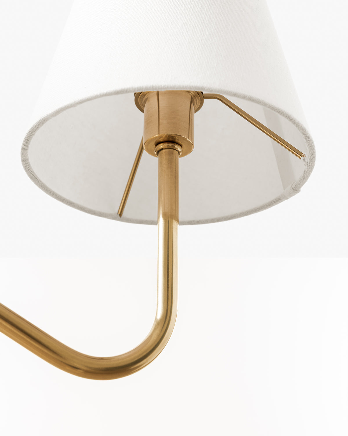 Close-up of the Holloway Floor Lamp in antique brass, featuring a white fabric shade and an elegant double-arm design with metal fittings, shown against a plain white background, by McGee & Co.