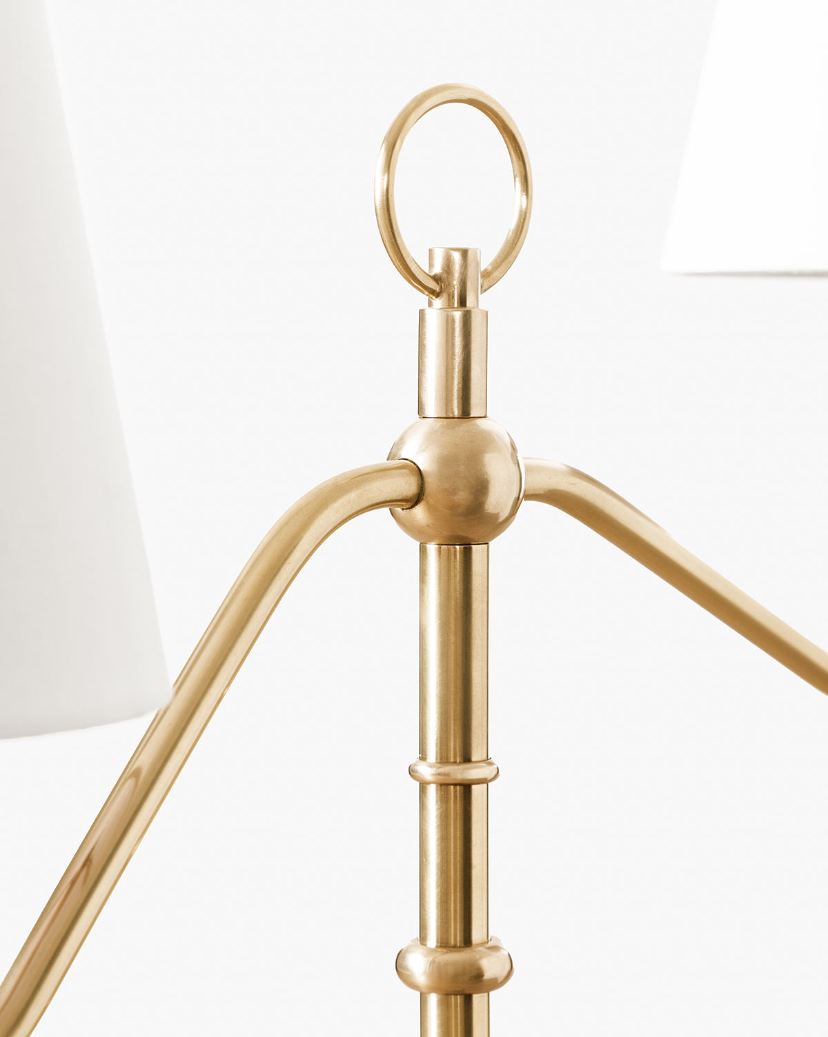 Close-up of the Holloway Floor Lamp in antique brass highlights its double-arm style, ring finial, and details of white lampshades, set against a plain white background by McGee & Co.