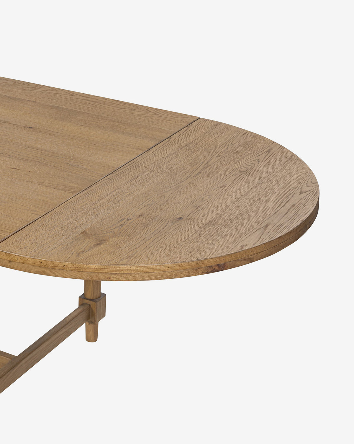 A close-up of the Kyler Oak Extension Dining Table showcases the join between its rectangular and rounded sections, featuring a light natural finish and visible wood grain, by McGee & Co.