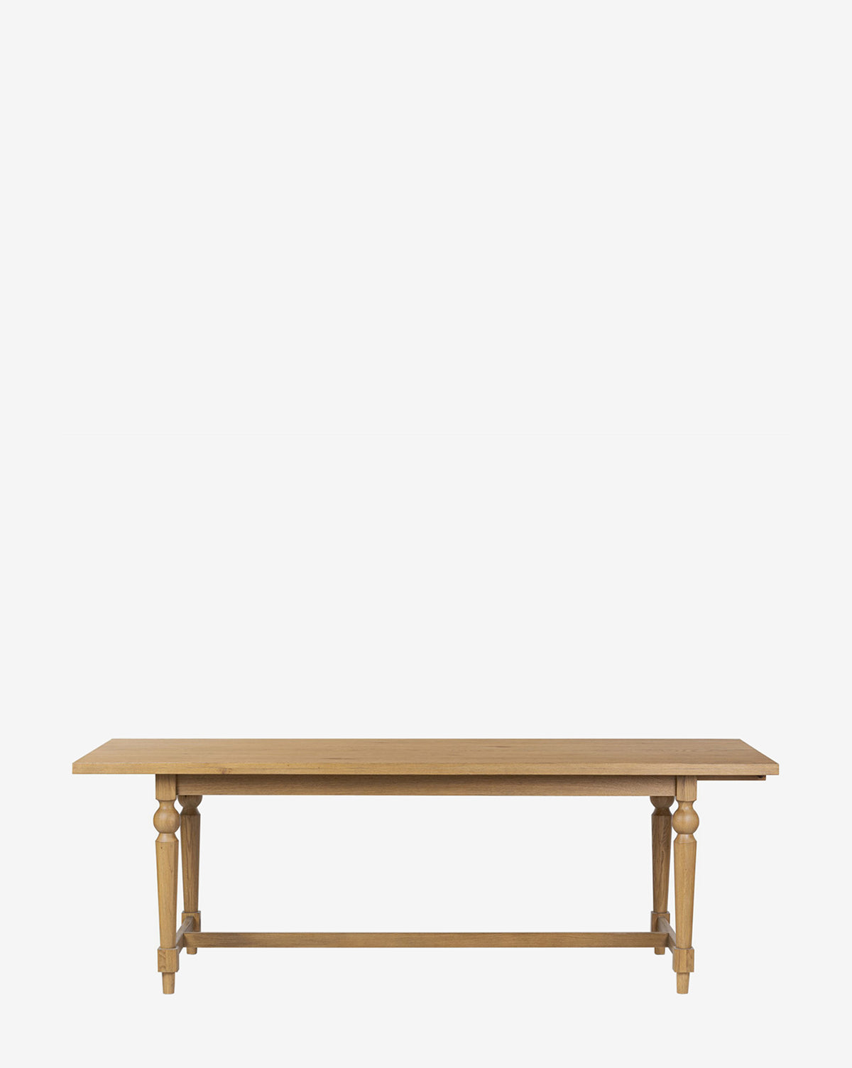 The Kyler Oak Extension Dining Table is a Scandinavian modern piece with a rectangular wooden top, turned legs, and a simple crossbar, shown against a plain white background by McGee & Co.