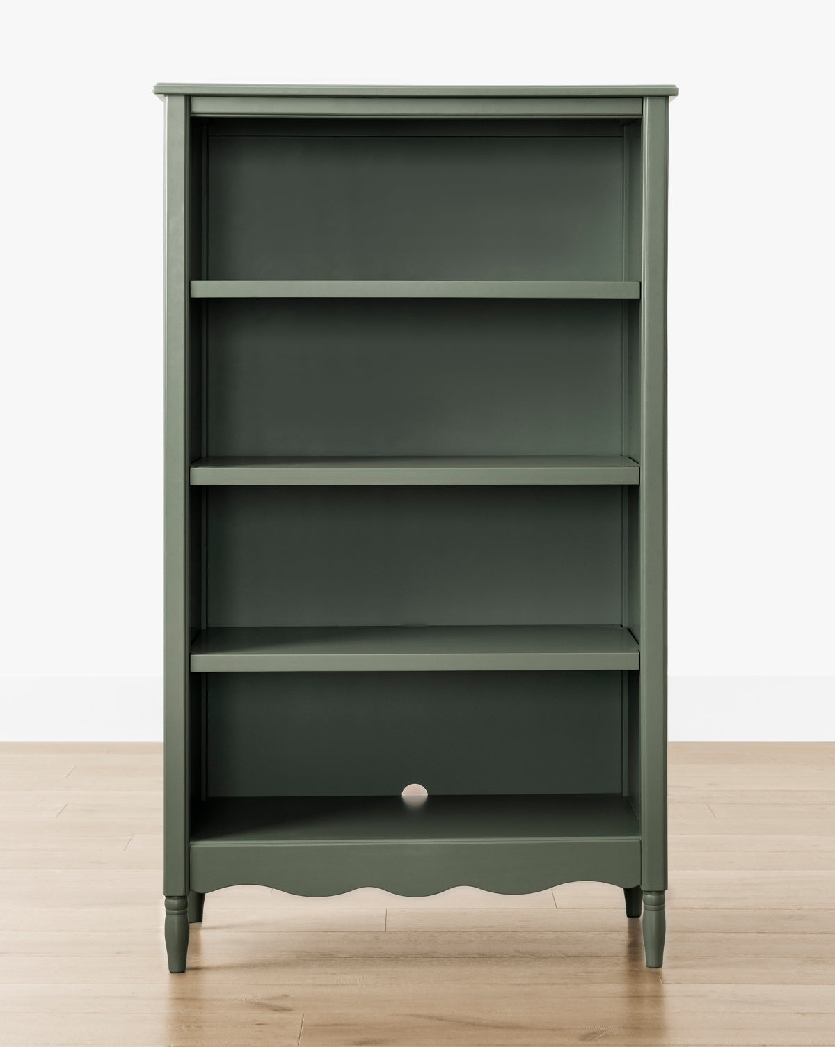The Liberty Bookcase, in dark green with four shelves and a small back panel hole, displays heirloom craftsmanship, by McGee & Co. It stands on a light wood floor against a white background.