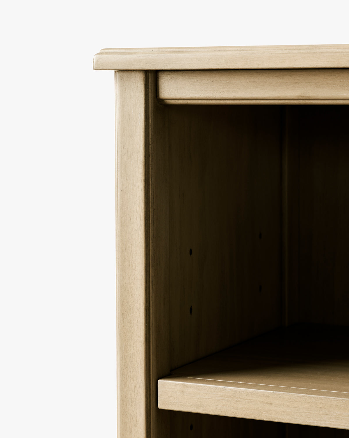 Close-up of the Liberty Bookcase’s top corner and side in a light finish, featuring one shelf and an empty interior, highlighting heirloom craftsmanship against a plain white background, by McGee & Co.