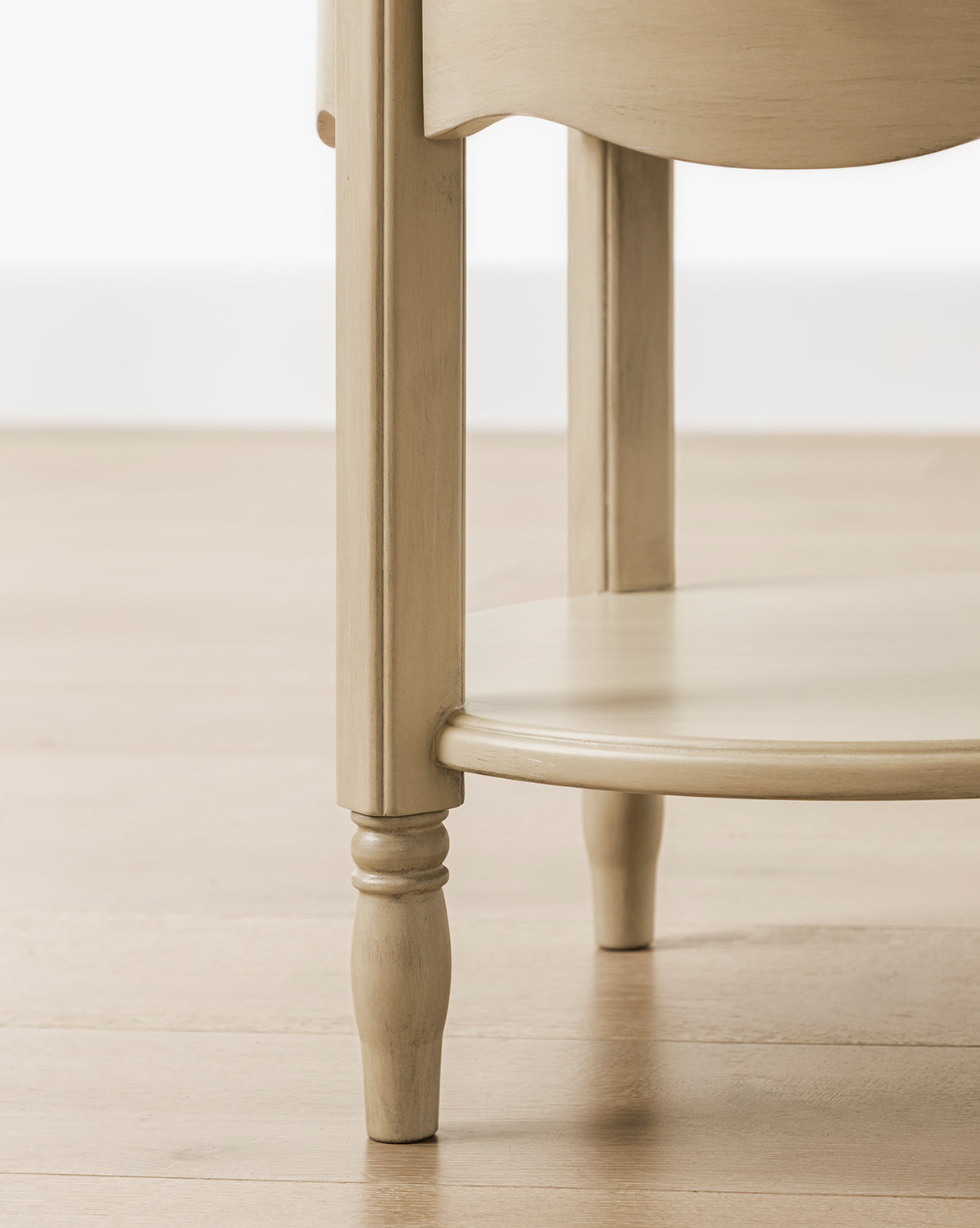 The Liberty Nightstand features turned legs and a circular bottom shelf, shown on a light wood floor against a white wall. GREENGUARD Gold Certified, its perfect for use as a nursery nightstand by McGee & Co.