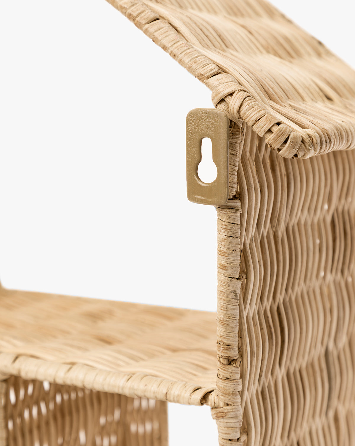 Close-up of the Maison Shelf, a woven light rattan wall shelf with a slanted roof, metal keyhole hanger, and natural finish. Its house-shaped design adds an organic touch to any space by McGee & Co.