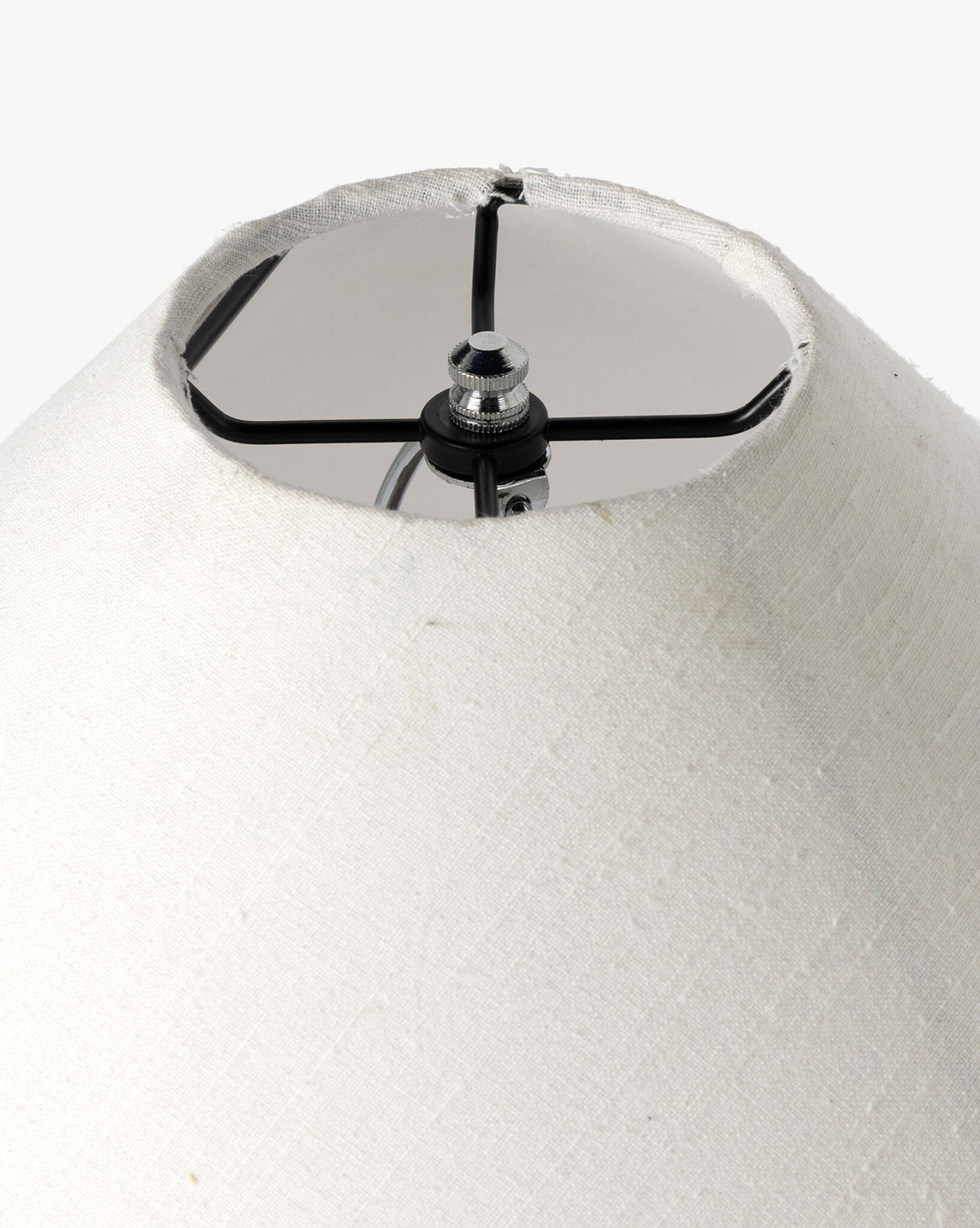A close-up of the Mays Table Lamp’s white fabric shade highlights its metal frame and central attachment, set against a simple background, by McGee & Co.