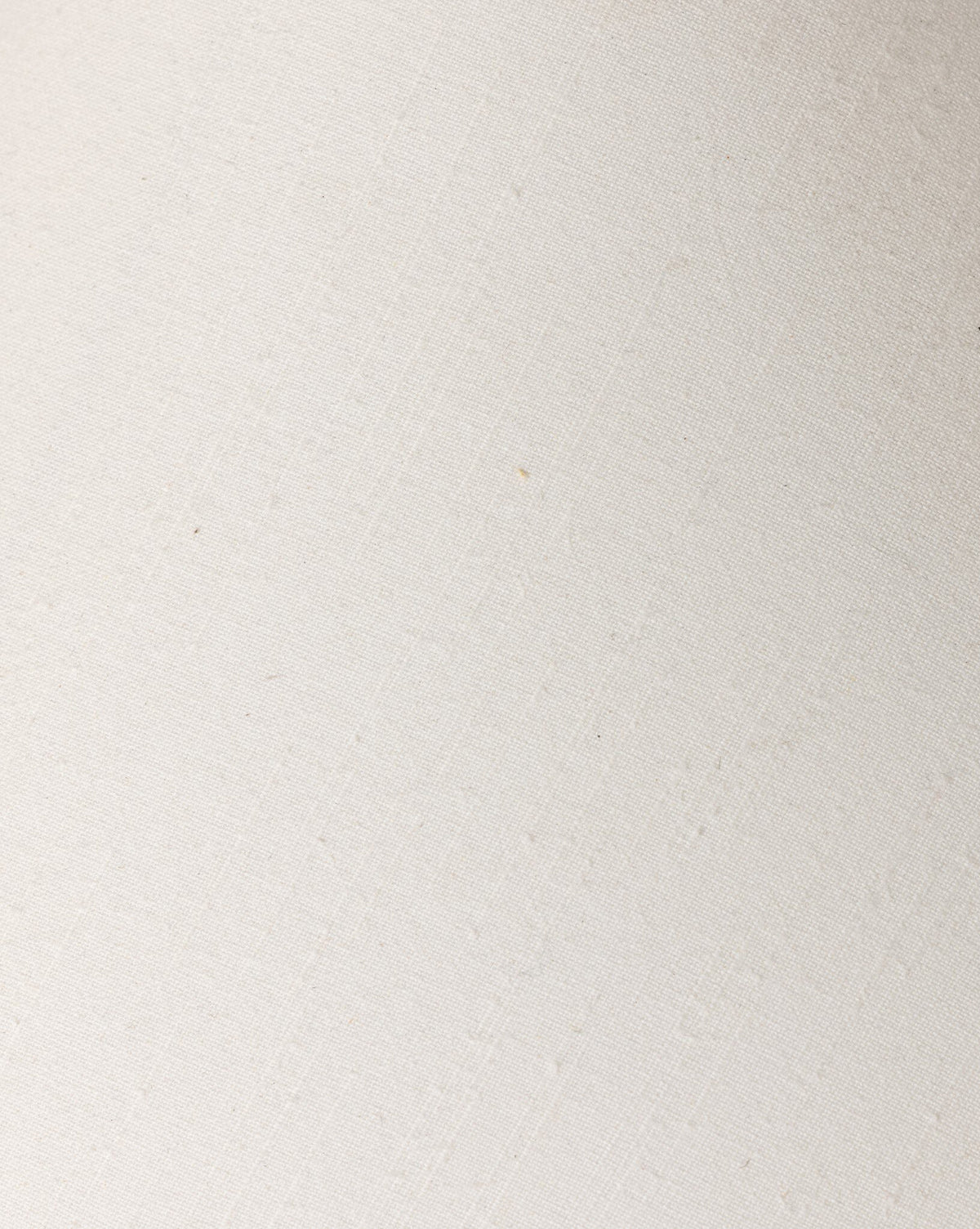 Close-up of the Mays Table Lamp’s textured, off-white surface reveals subtle diagonal lines and slight imperfections, evoking handcrafted details similar to those on a vintage clay jar, by McGee & Co.