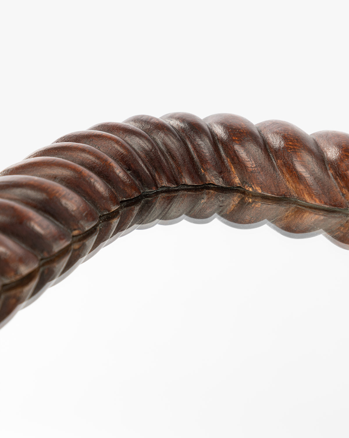 Close-up of the Mayweather Shelf Mirror’s twisted, rope-inspired frame in dark red walnut with a smooth, polished finish, curving elegantly across a white background, by McGee & Co.