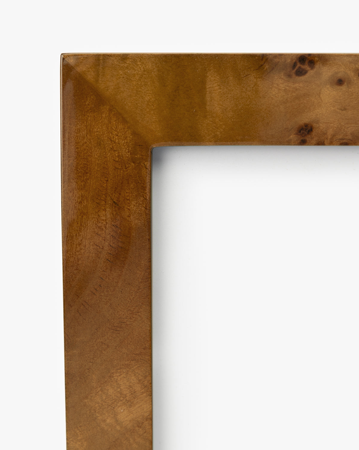 Close-up of the top left corner of an Oliver Burl 4x6 Frame (Set of 2), featuring a smooth, polished finish and natural grain patterns—an ideal accent to elevate your home decor against a crisp white background, by McGee & Co.