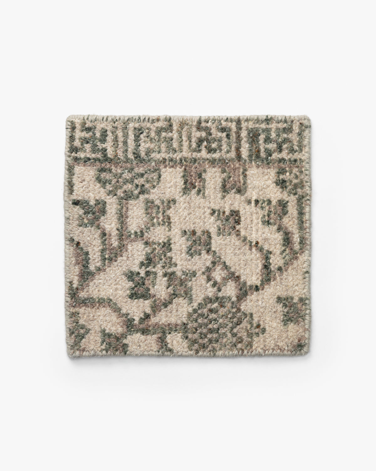 The Orsino Hand-Knotted Rug Swatch is a rectangular wool sample with a beige background and abstract green and brown geometric and floral patterns, shown on a plain white surface by McGee & Co.