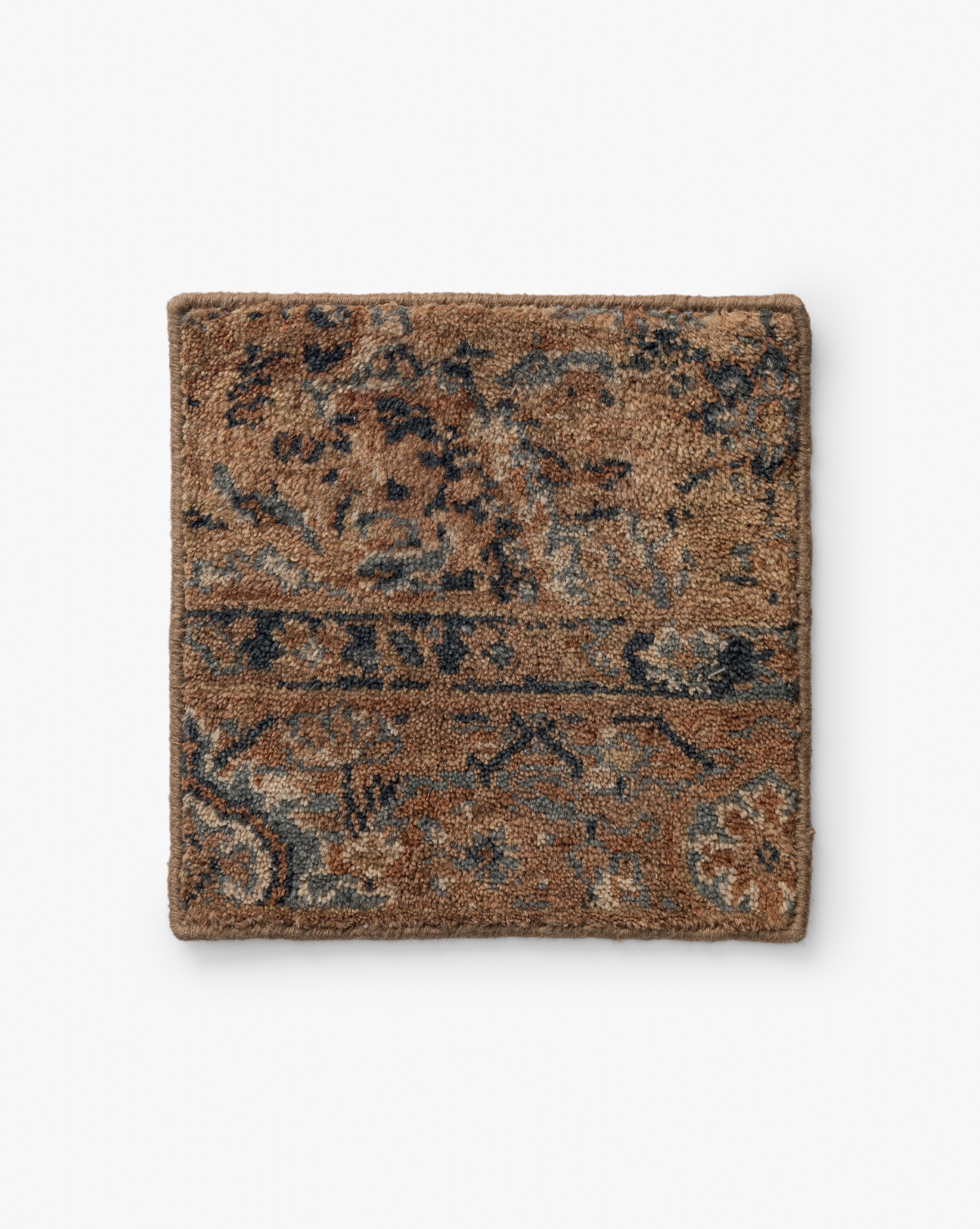 The Piedmont Hand-Knotted Wool Rug Swatch features a square sample of textured brown carpet with intricate, vintage-style floral and geometric patterns in blue and gray, highlighting heirloom craftsmanship on a white background, by McGee & Co.