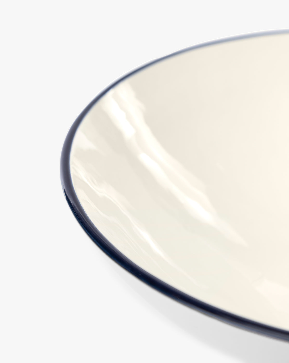 Close-up of the glossy, cream-colored Pritchard Serving Bowl with a dark rim, shown against a white background by McGee & Co.