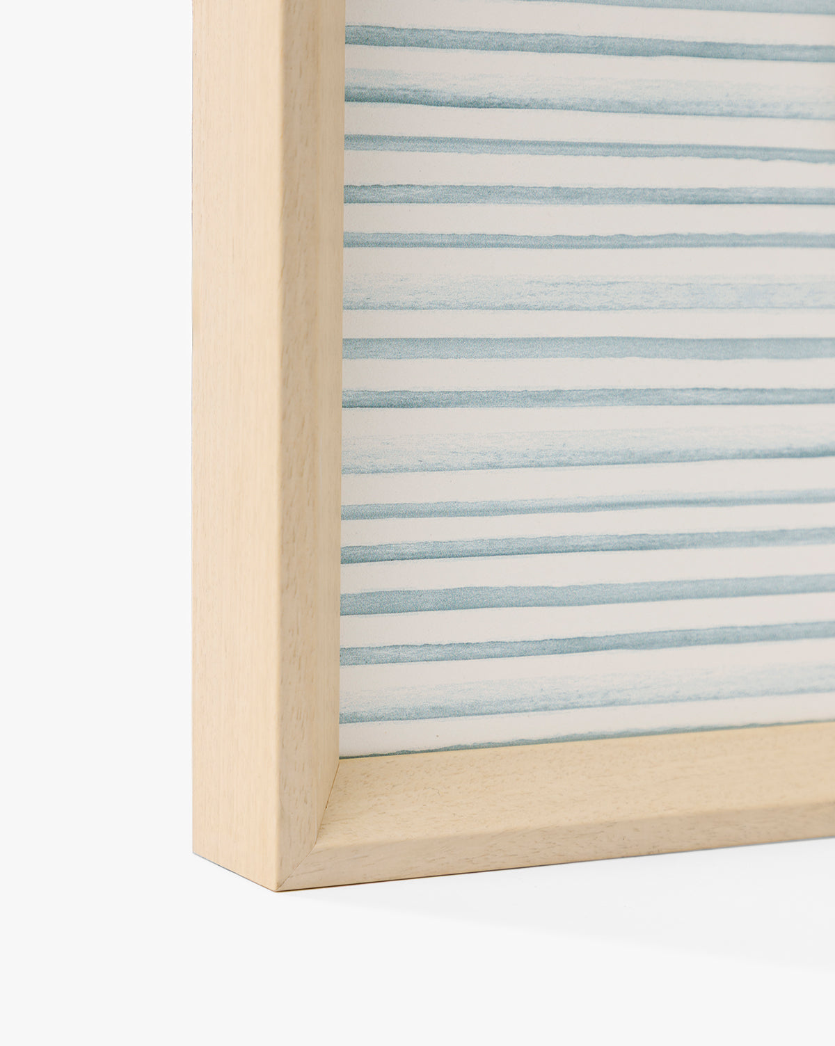Close-up of the corner of the Seaside Village light wooden frame, featuring abstract horizontal blue and white stripes—perfect for adding coastal charm to any space, by McGee & Co.