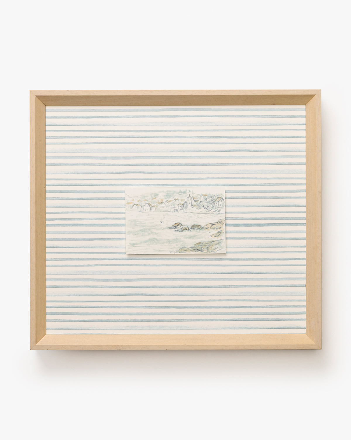 Seaside Village features a subtle landscape centered on evenly spaced blue lines, evoking coastal charm within a light wooden frame and set against a crisp white backdrop, by McGee & Co.