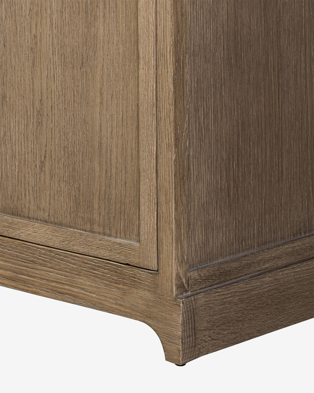 Close-up of the Stonington Oak Sideboard’s corner, showing its light brown, weathered washed oak finish and simple, classic base for a vintage-inspired look, by McGee & Co.