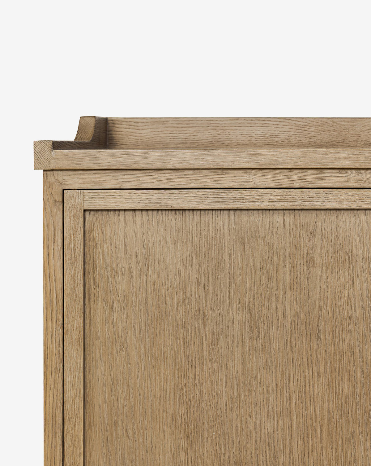 A close-up of the Stonington Oak Sideboards top corner highlights its light natural finish, clean lines, and simple modern design against a plain white background, by McGee & Co.