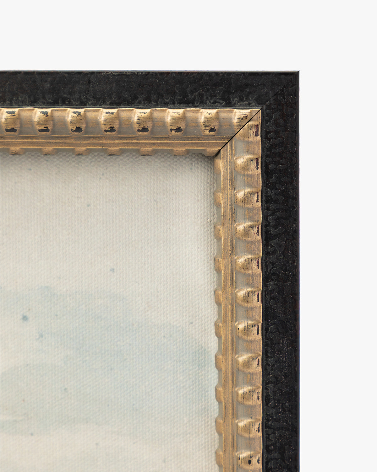 Close-up of the top-right corner of the View of St Catherines Hill Near Guildford by Charles Claude Pyne, featuring a textured black outer edge, decorative gold inner edge, and part of a canvas with light, subtle colors by McGee & Co.