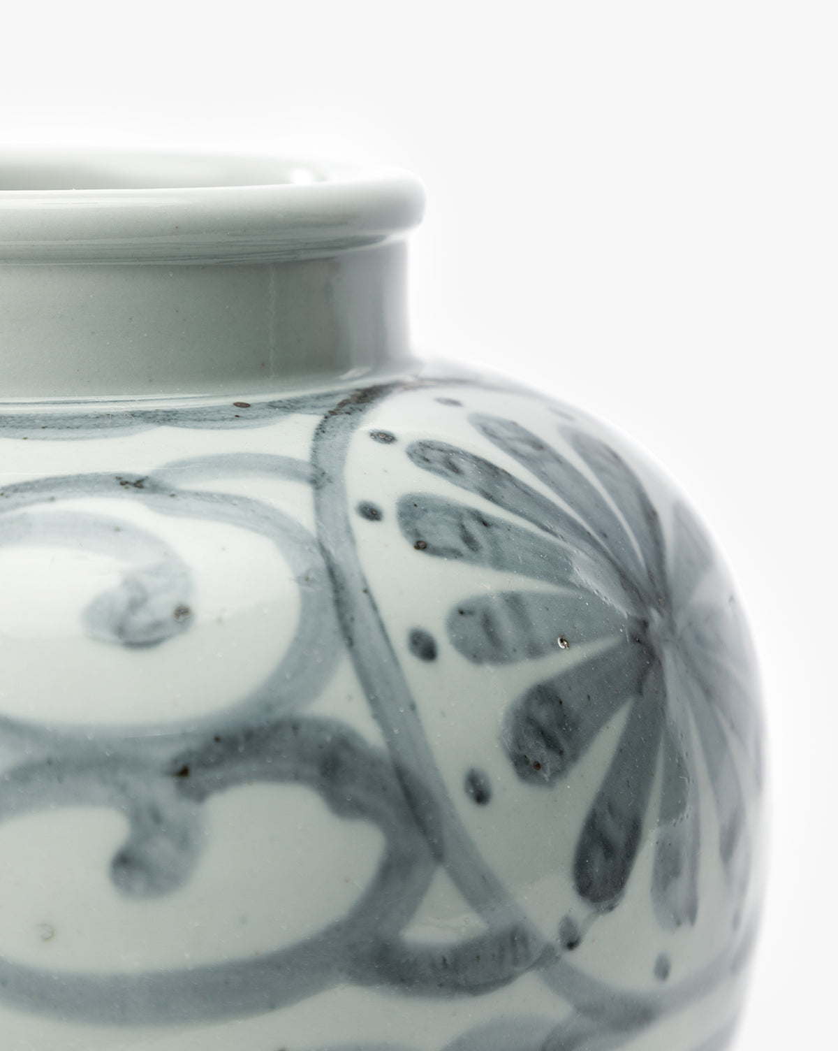 Close-up of the Wilfred Vase, a light gray ceramic piece with a glossy finish, accented by dark gray hand-painted floral and swirling designs. Set against a plain white background, by McGee & Co.
