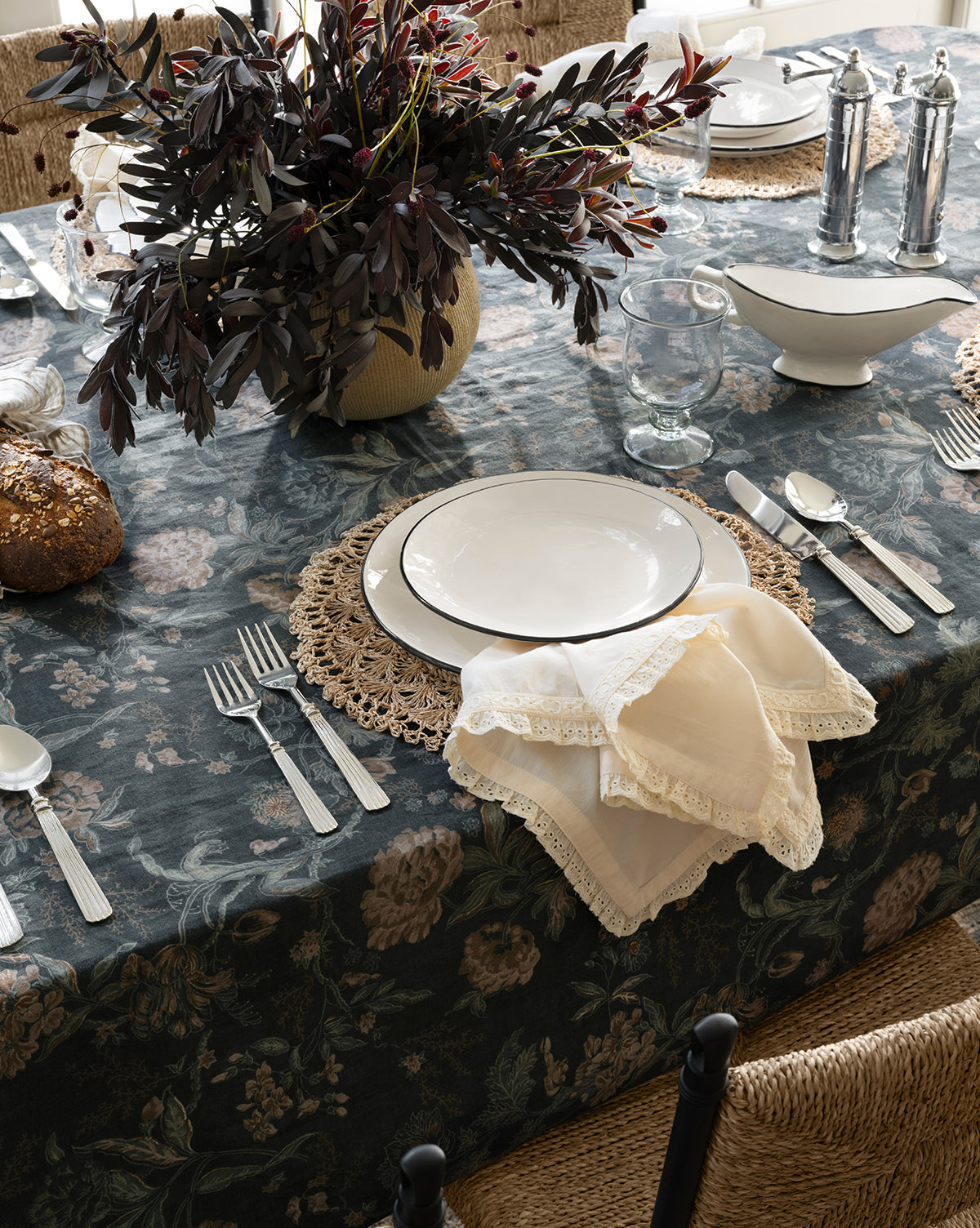 A table with plates, silverware, and a European Chrome Pepper Mill with an adjustable steel grinding mechanism, by McGee & Co.
